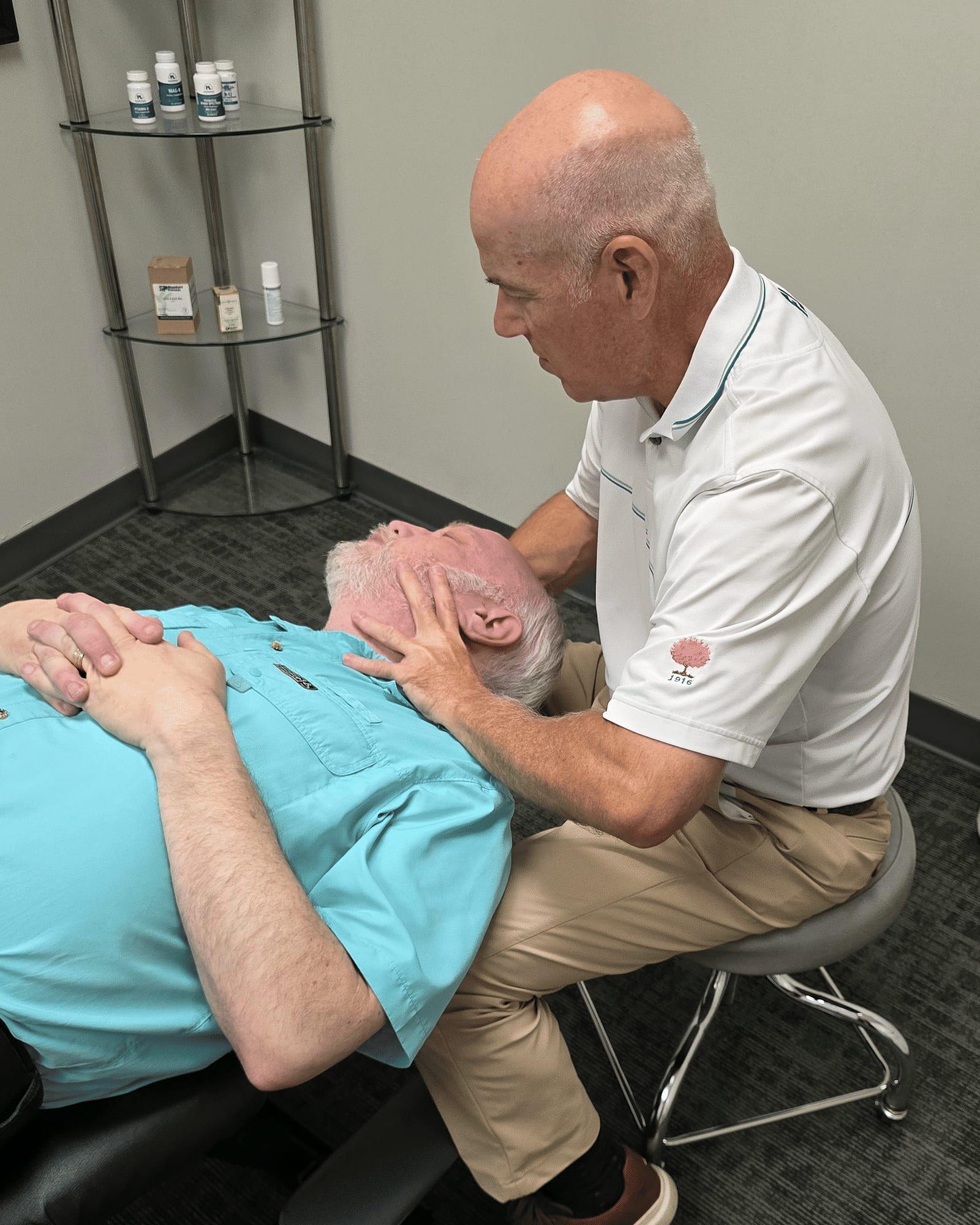 Dr. Keith Jensen performs a neck adjustment on a patient at Mansfield Spinal Care in Mansfield, Texas.