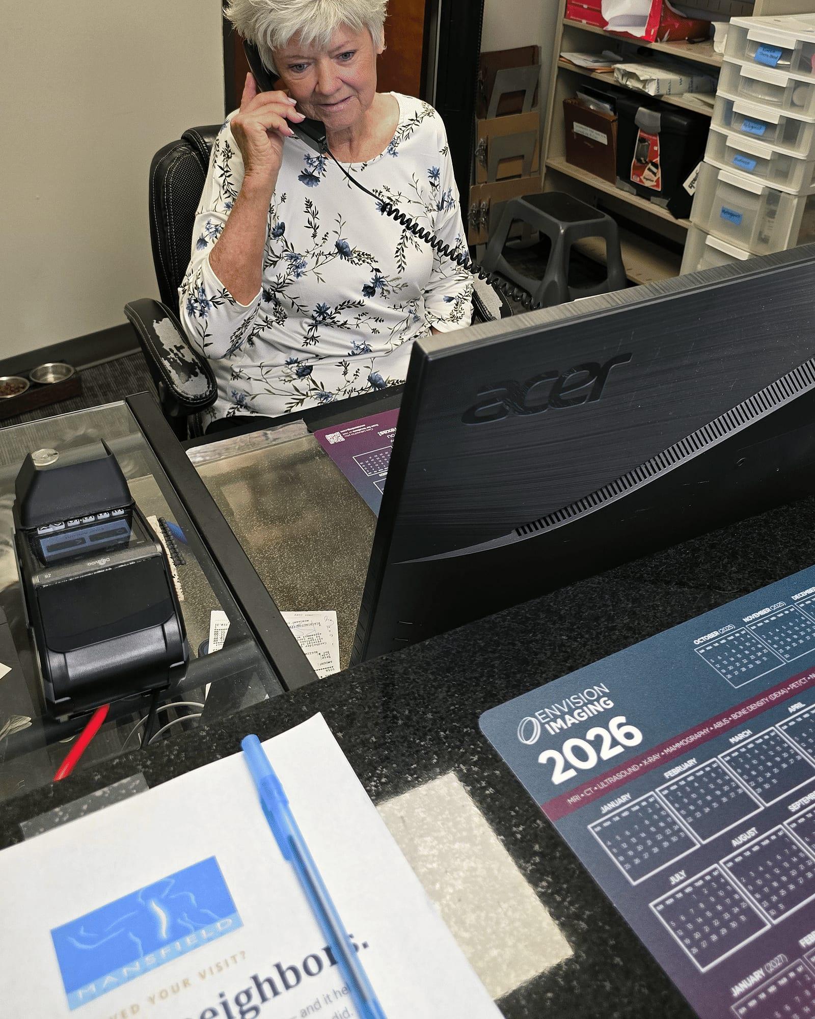 Debbie answers a patient call at the front desk of Mansfield Spinal Care in Mansfield, Texas.