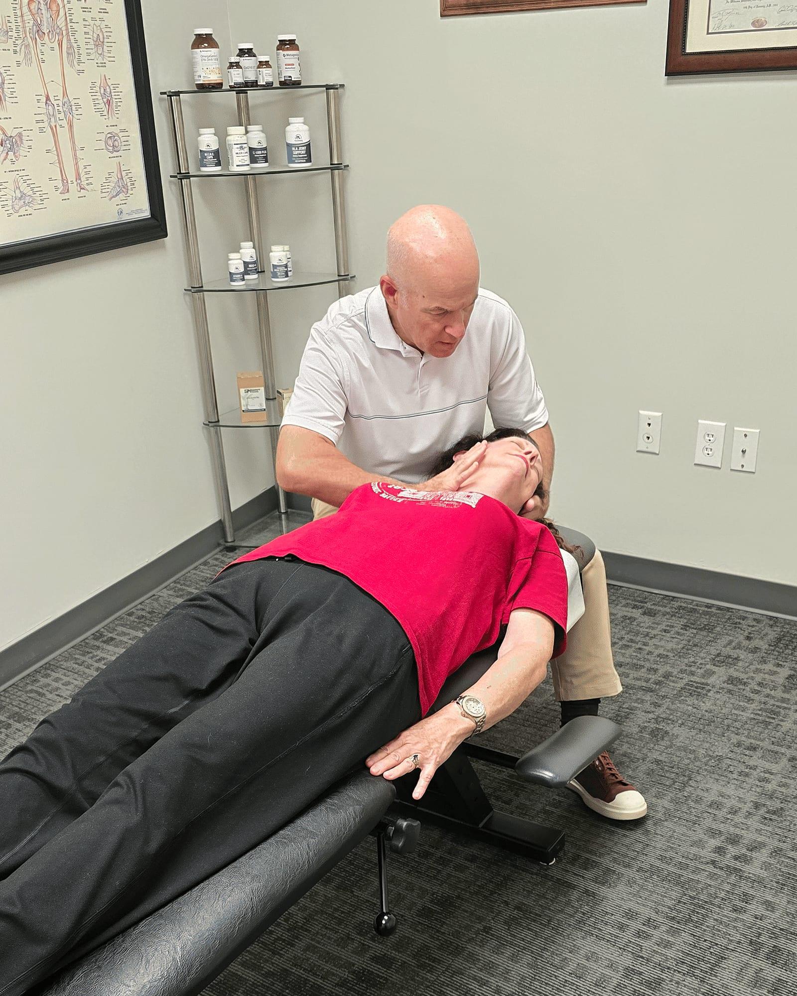 Dr. Keith Jensen performs a neck adjustment on a patient at Mansfield Spinal Care in Mansfield, Texas.